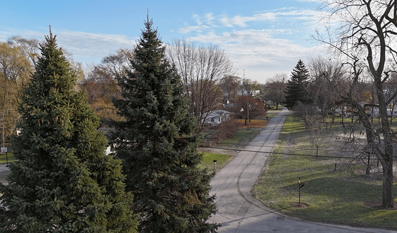 Drone inspecting rooftop and eaves for debris during spring lawn care