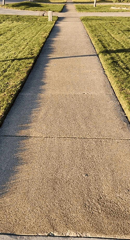 Front yard of a home with perfectly cut grass and defined mowing patterns