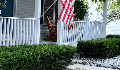 Man trimming shrubs along sidewalk with clean-cut hedges